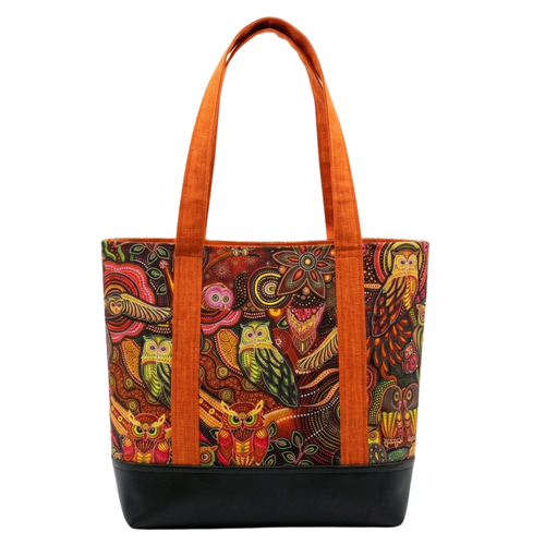 Handmade cotton tote bag with bohemian owl pattern in warm tones, burnt orange handles, and structured black base