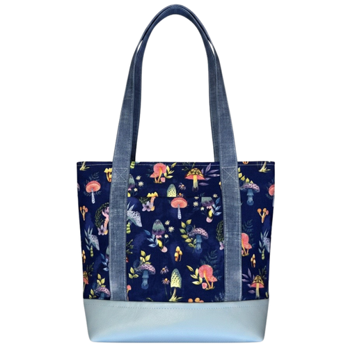 Handmade cotton tote bag featuring whimsical mushrooms on a navy background with chambray handles and powder blue faux leather base