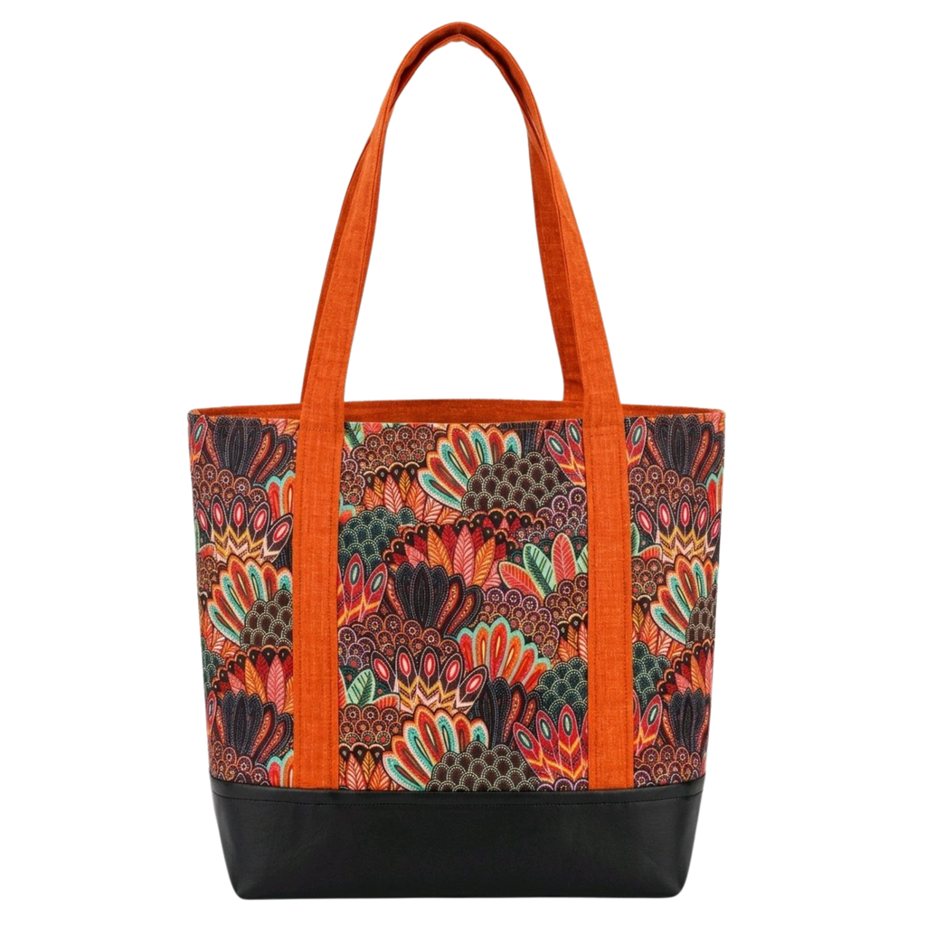 Handmade cotton tote bag with owl feather pattern in warm tones, burnt orange handles, and structured black base