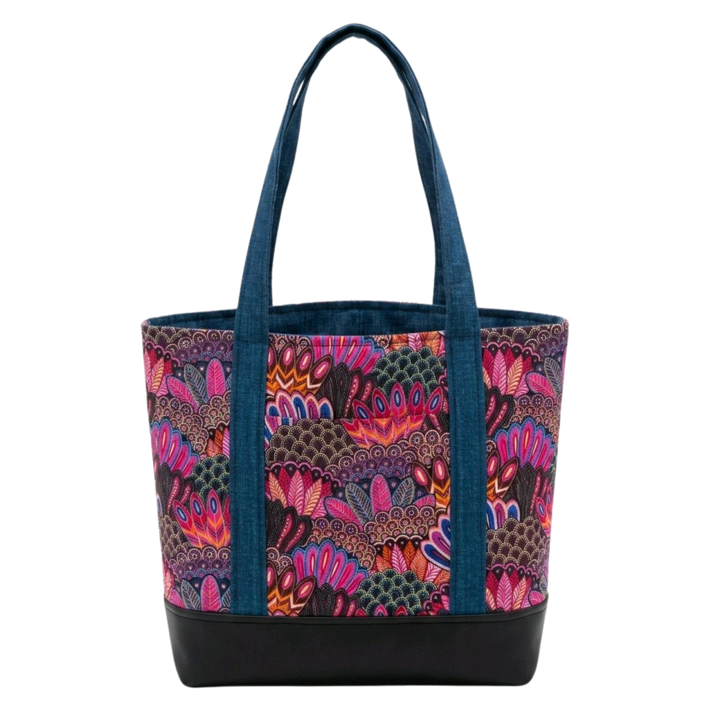 Handmade cotton tote bag with vibrant owl feather pattern in pink and teal tones, teal handles, and structured black base
