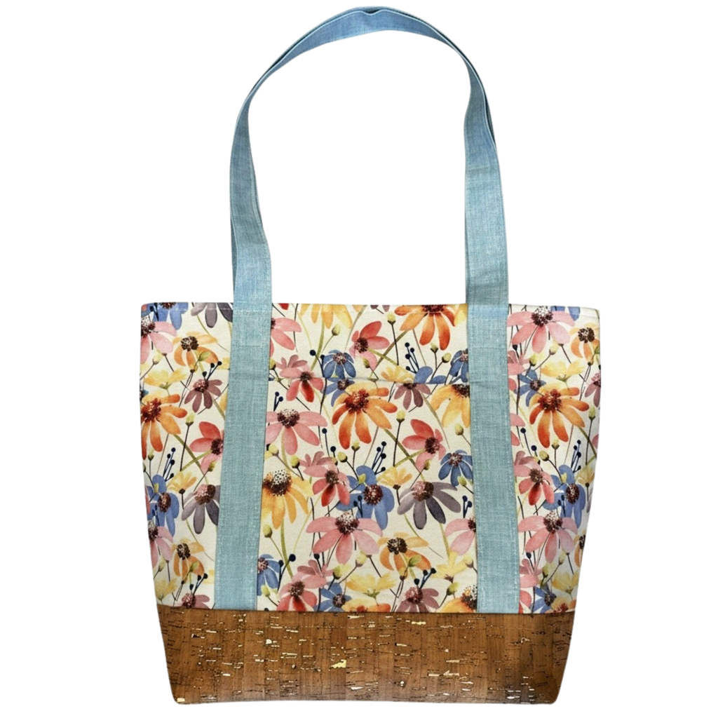 Handmade cotton tote bag featuring colorful wildflowers with sky blue handles and natural cork base