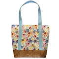 Handmade cotton tote bag featuring colorful wildflowers with sky blue handles and natural cork base