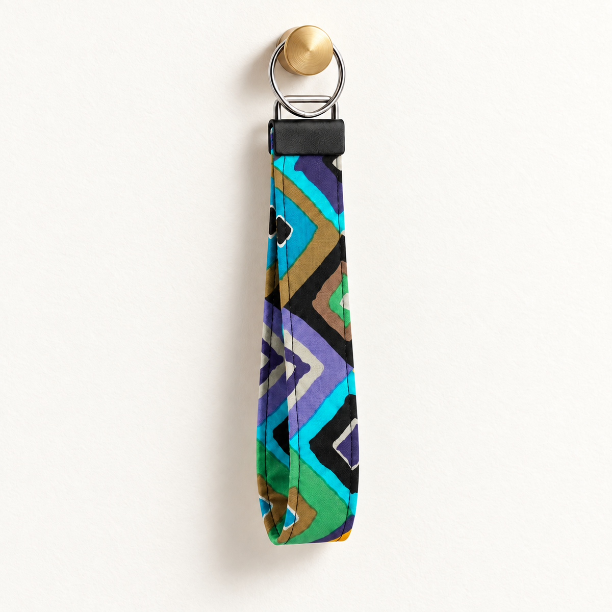 Angle Management – Fabric Wristlet Keychain hanging from a gold wall knob