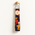 Apple of My Eye – Fabric Wristlet Keychain hanging from a gold wall knob