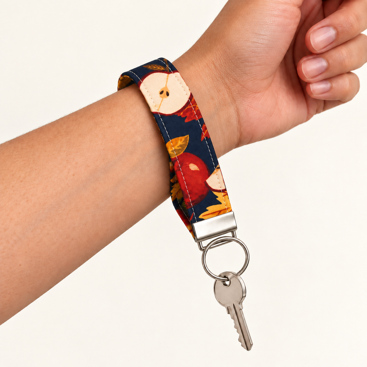 Apple of My Eye – Fabric Wristlet Keychain worn around a wrist with a key attached