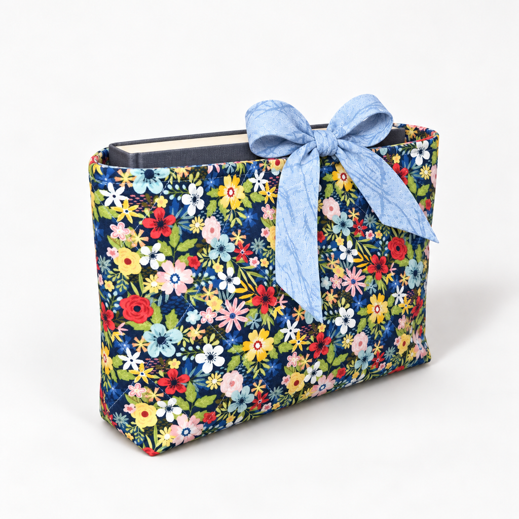 Bloom Between the Lines book sleeve with rounded pale blue patterned bow, three-quarter view with hardcover book inside