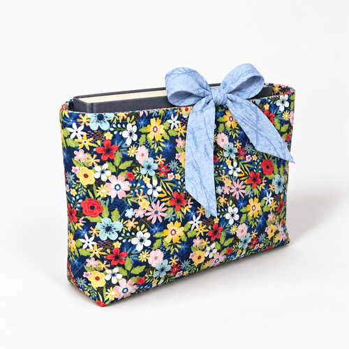 Bloom Between the Lines book sleeve with rounded pale blue patterned bow, three-quarter view with hardcover book inside