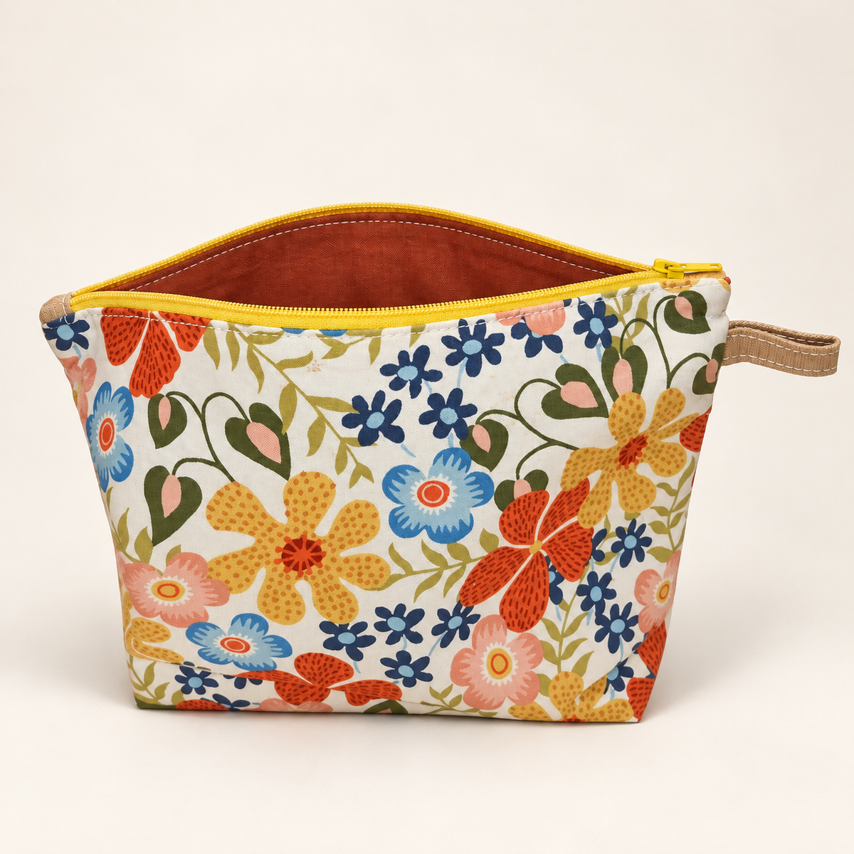 Bloom Service retro floral pouch standing with yellow zipper and rust lining.