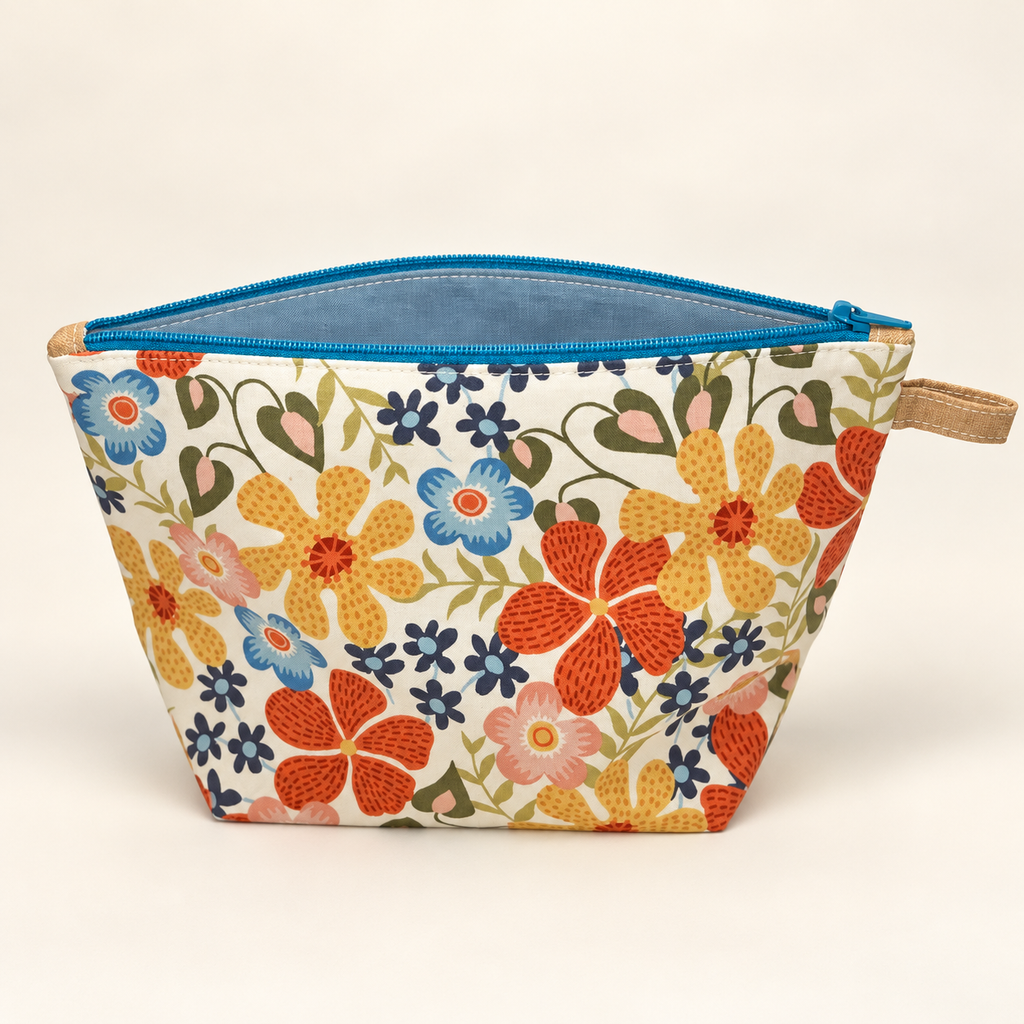 Bloom Service retro floral pouch standing with teal zipper and blue lining.