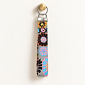 Bloom With Attitude – Fabric Wristlet Keychain hanging from a gold wall knob