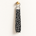 Bone to Pick – Fabric Wristlet Keychain hanging from a gold wall knob