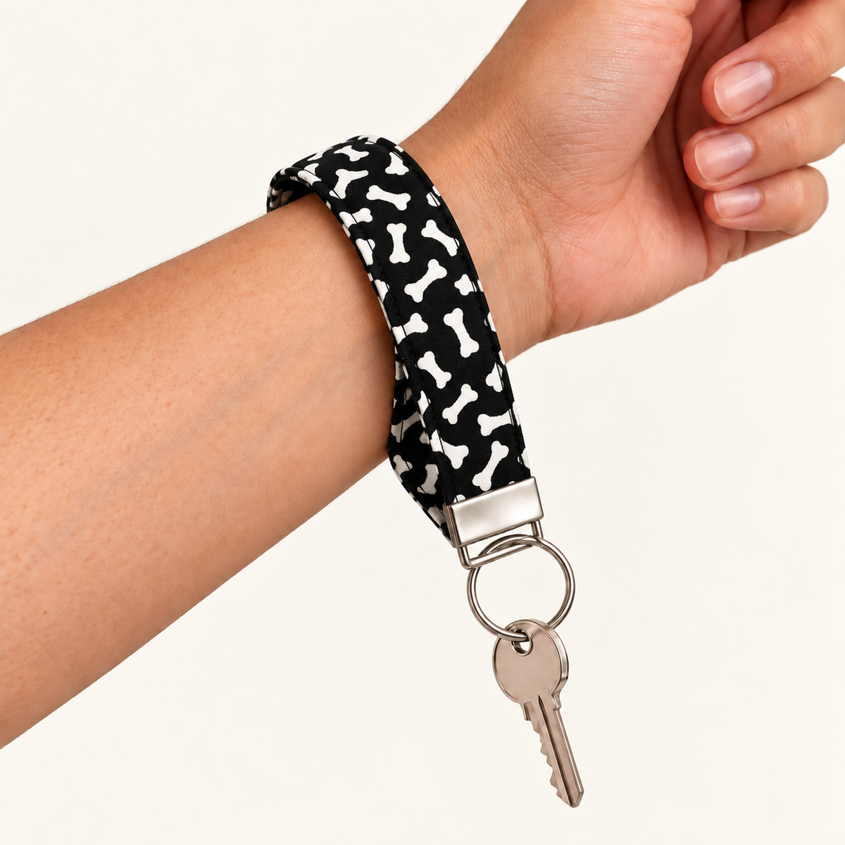 Bone to Pick – Fabric Wristlet Keychain worn around a wrist with a key attached