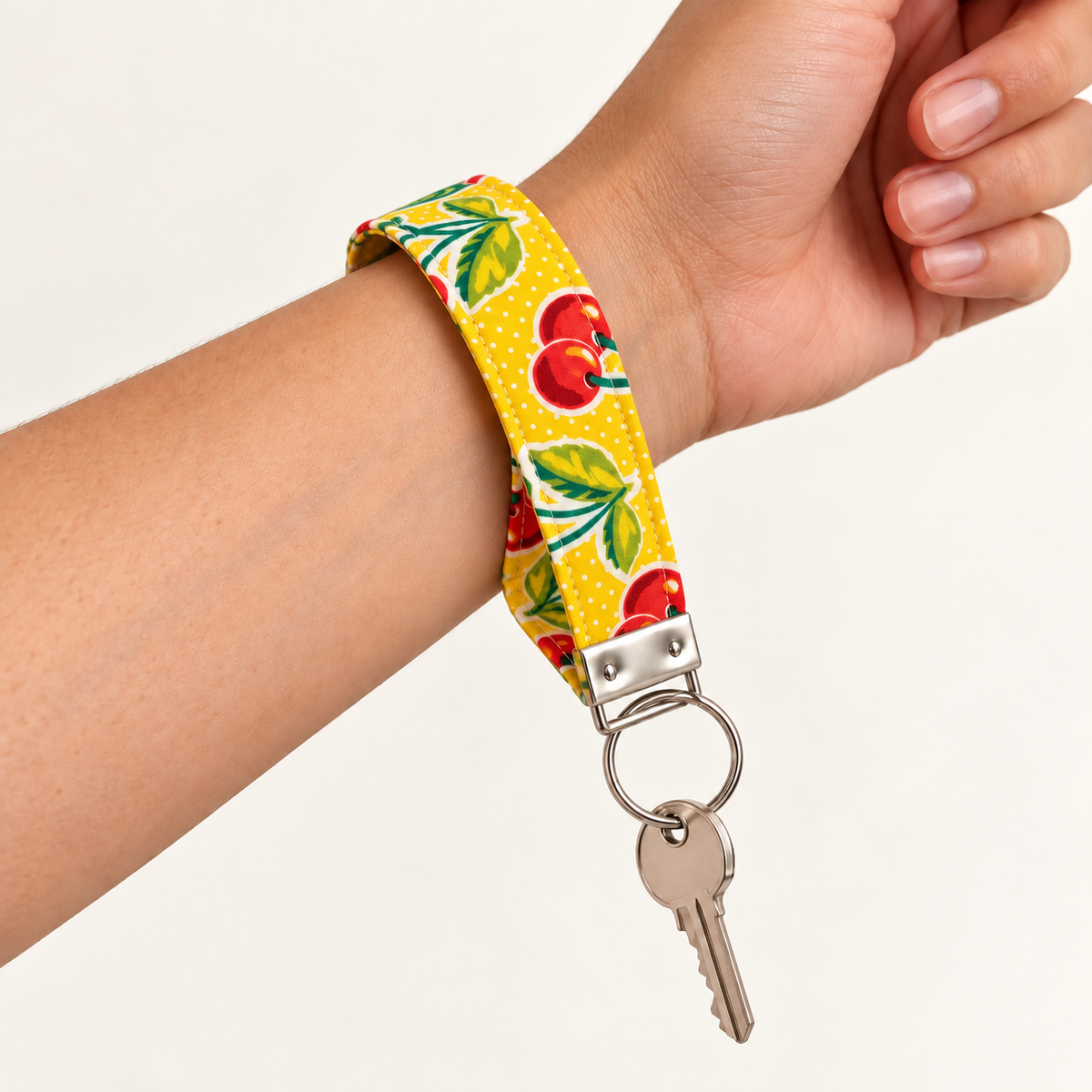 Cherry on Top wristlet loop worn around the wrist with a key attached