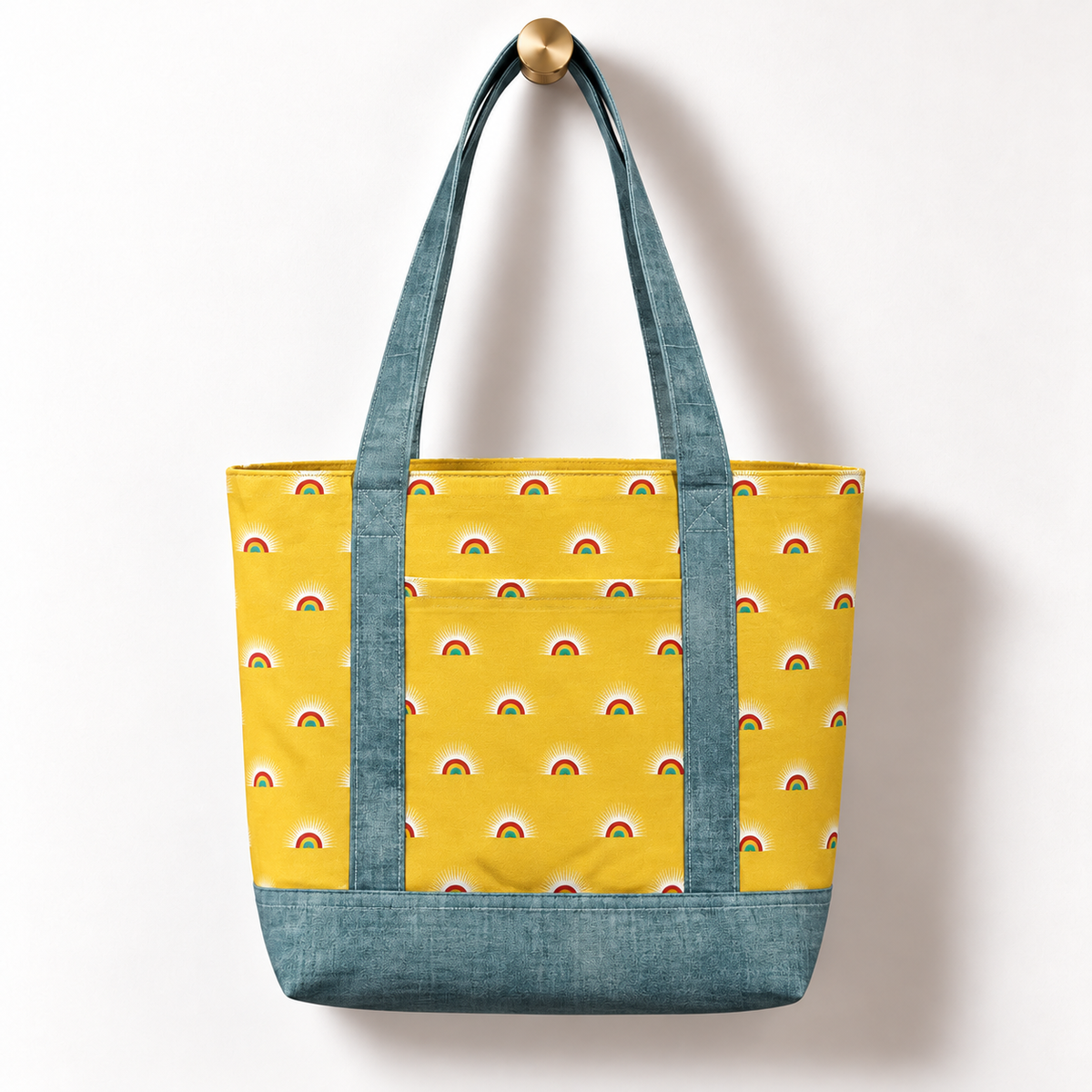 Sunshine Rainbow Cotton Tote Bag – Chambray Blue, hanging from a gold wall knob