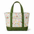 Floral tote bag with green handles and trim on a white background