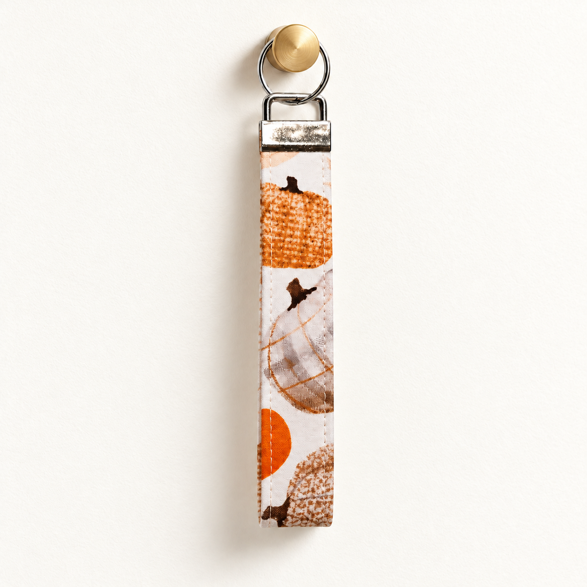 Gourd Vibes Only – Fabric Wristlet Keychain hanging from a gold wall knob