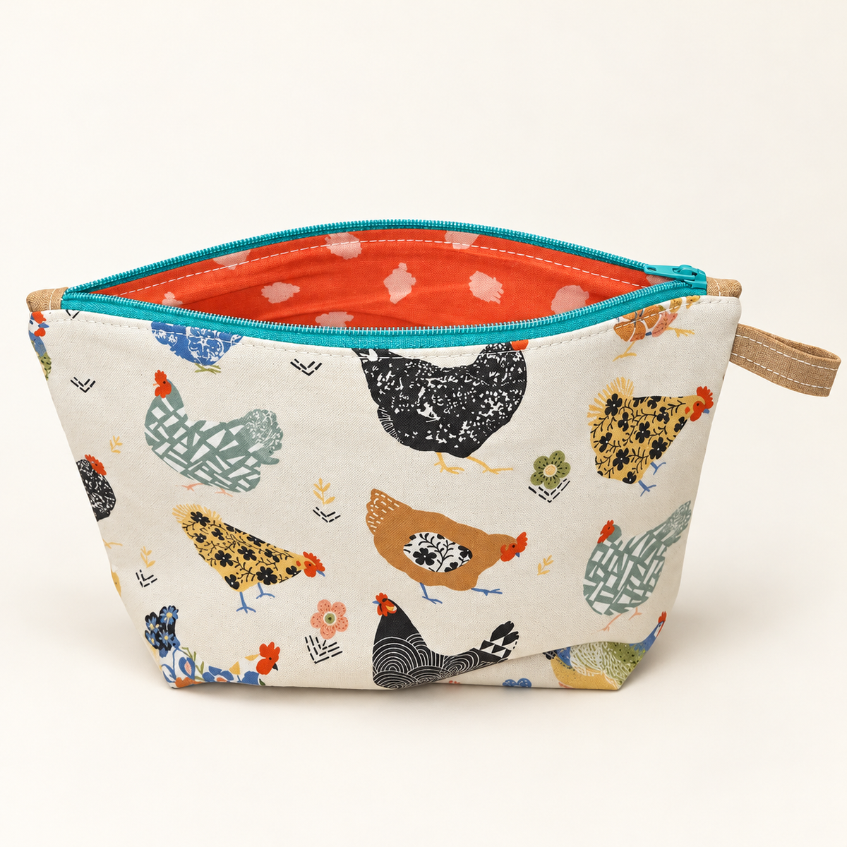 Hen Party chicken print cotton pouch with teal zipper, standing view showing coral patterned lining