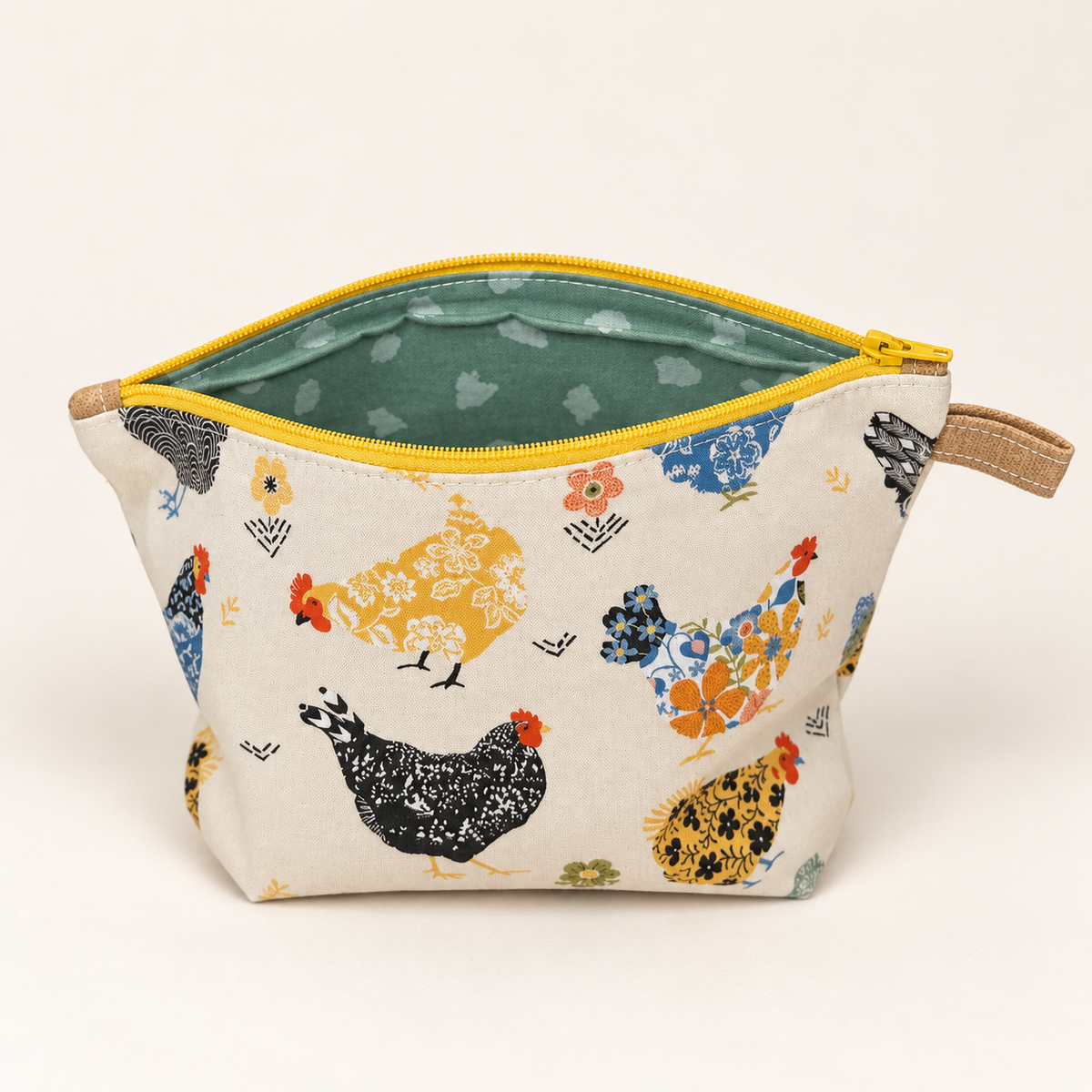 Hen Party chicken print cotton pouch with yellow zipper, standing view showing sage patterned lining