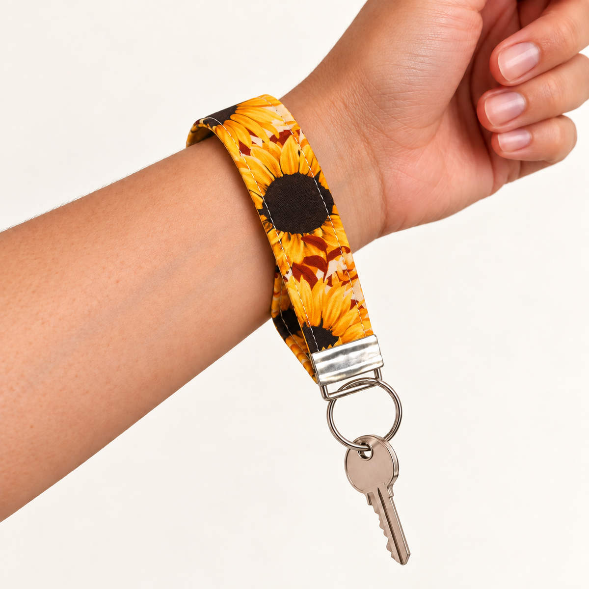 Here Comes the Sun – Fabric Wristlet Keychain worn around a wrist with a key attached