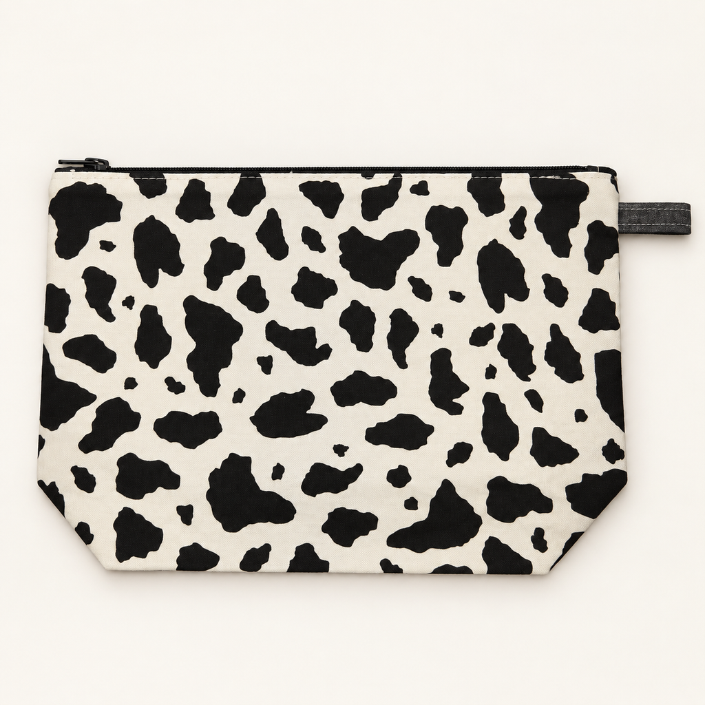 Moo-d Swing cow print cotton pouch laid flat with black zipper.