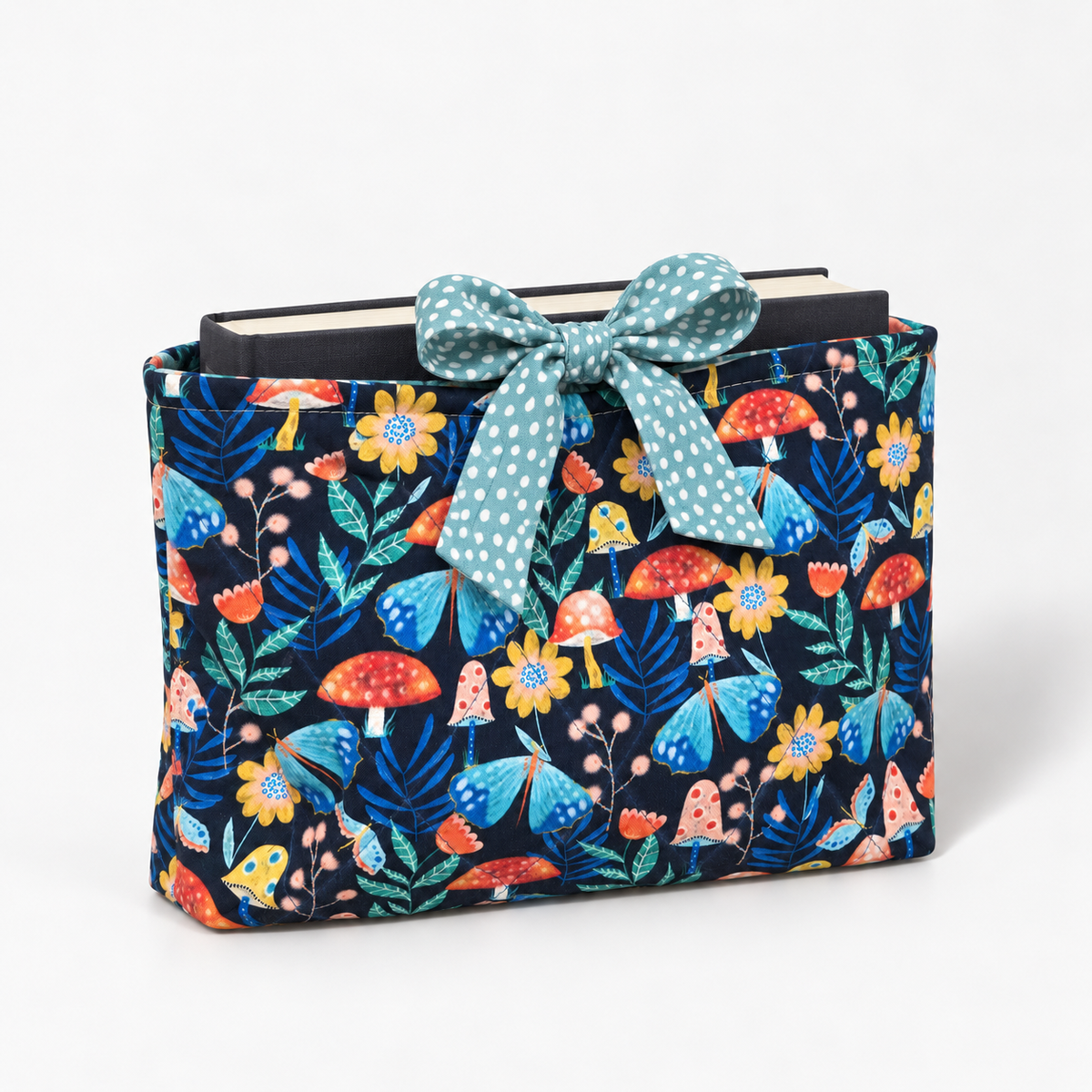 Moth to a Plot book sleeve with rounded seafoam polka-dot bow, three-quarter view with hardcover book inside