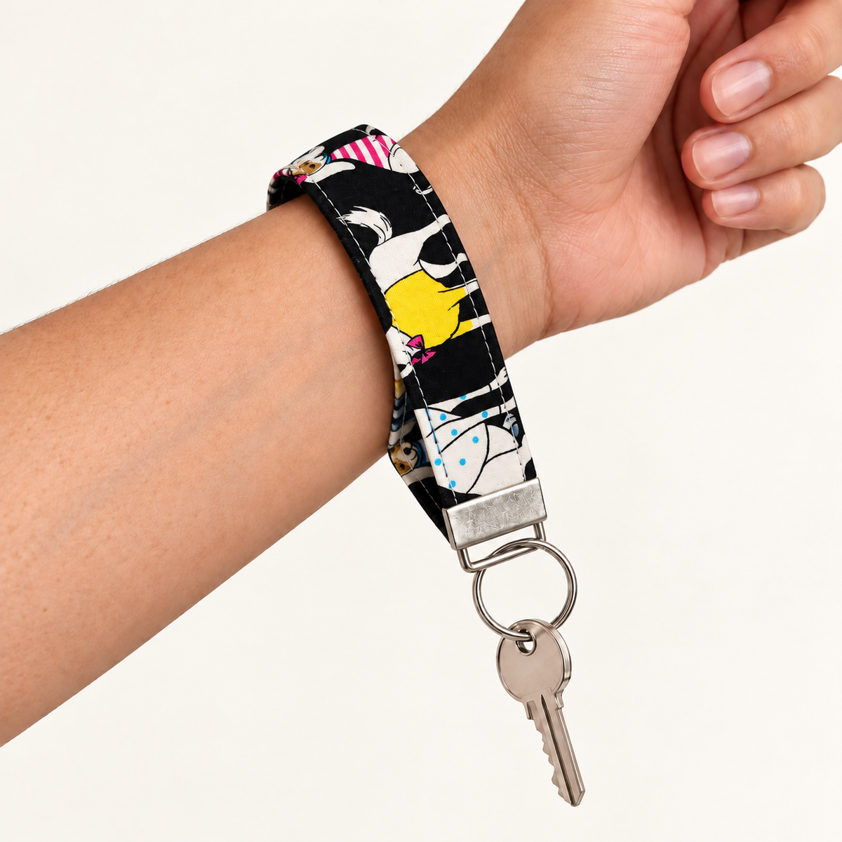 Party Animals – Fabric Wristlet Keychain worn around a wrist with a key attached