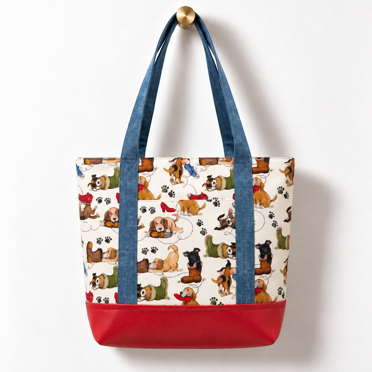 Playful Puppies Cotton Tote Bag – Red & Blue hanging on a gold knob