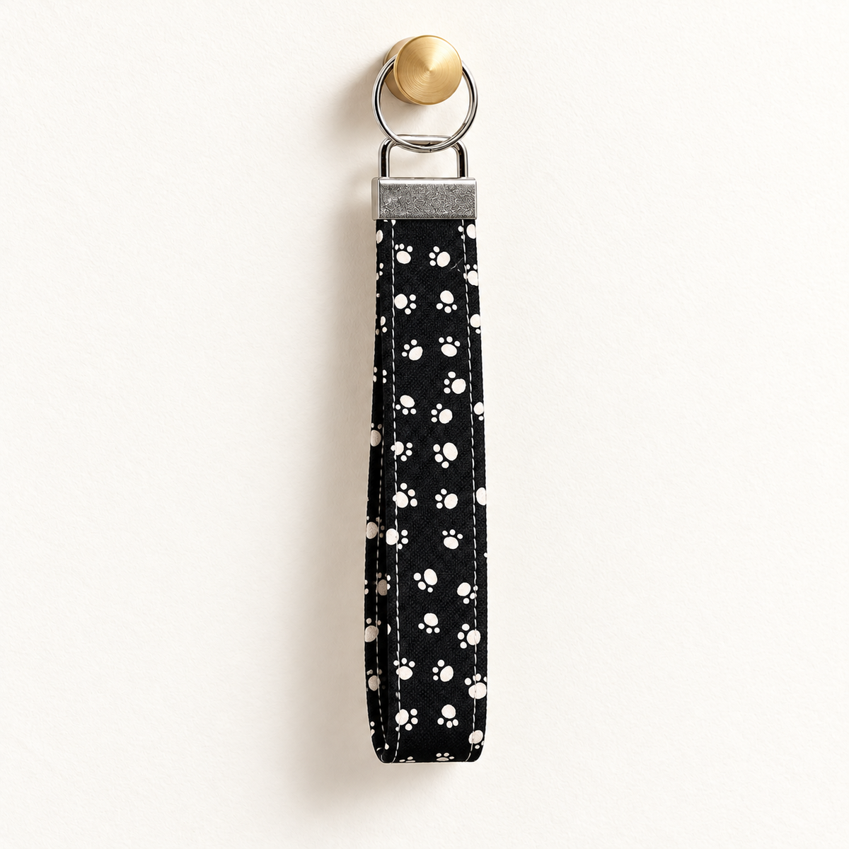 Paws Off – Fabric Wristlet Keychain hanging from a gold wall knob