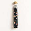 Petal After Hours – Fabric Wristlet Keychain hanging from a gold wall knob