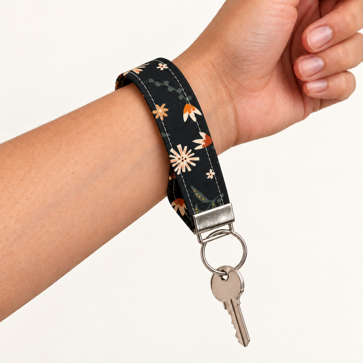 Petal After Hours – Fabric Wristlet Keychain worn around a wrist with a key attached