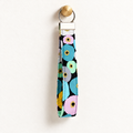 Petal Pop – Fabric Wristlet Keychain hanging from a gold wall knob