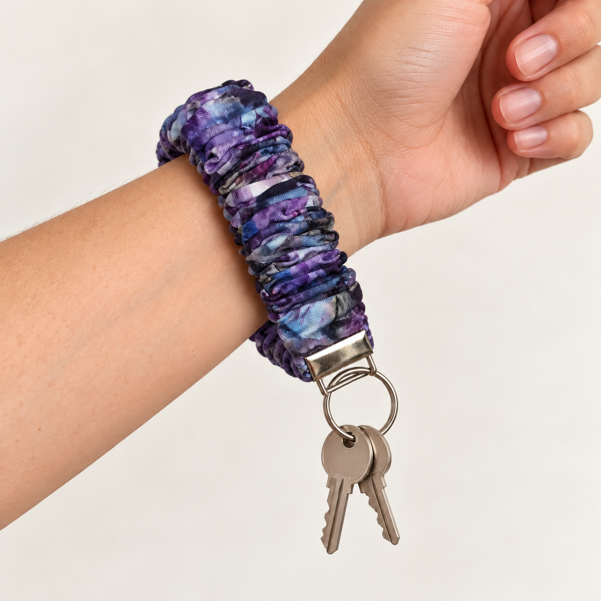purple watercolor scrunchie wristlet worn on wrist with keys