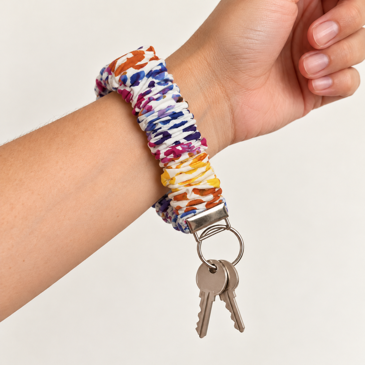 rainbow cheetah scrunchie wristlet worn on wrist with keys