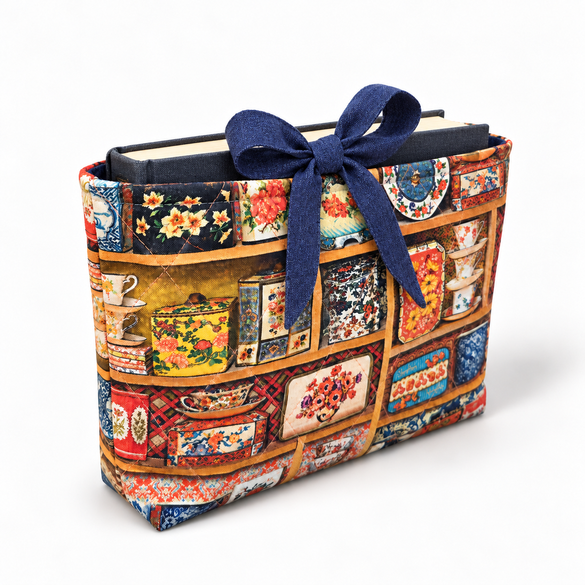 Shelf Indulgence book sleeve with rounded deep blue bow, three-quarter view with hardcover book inside