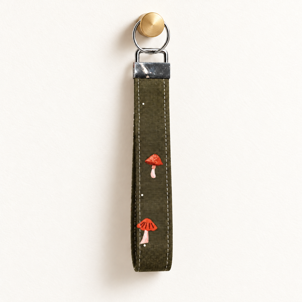 Shroom Service – Fabric Wristlet Keychain hanging from a gold wall knob