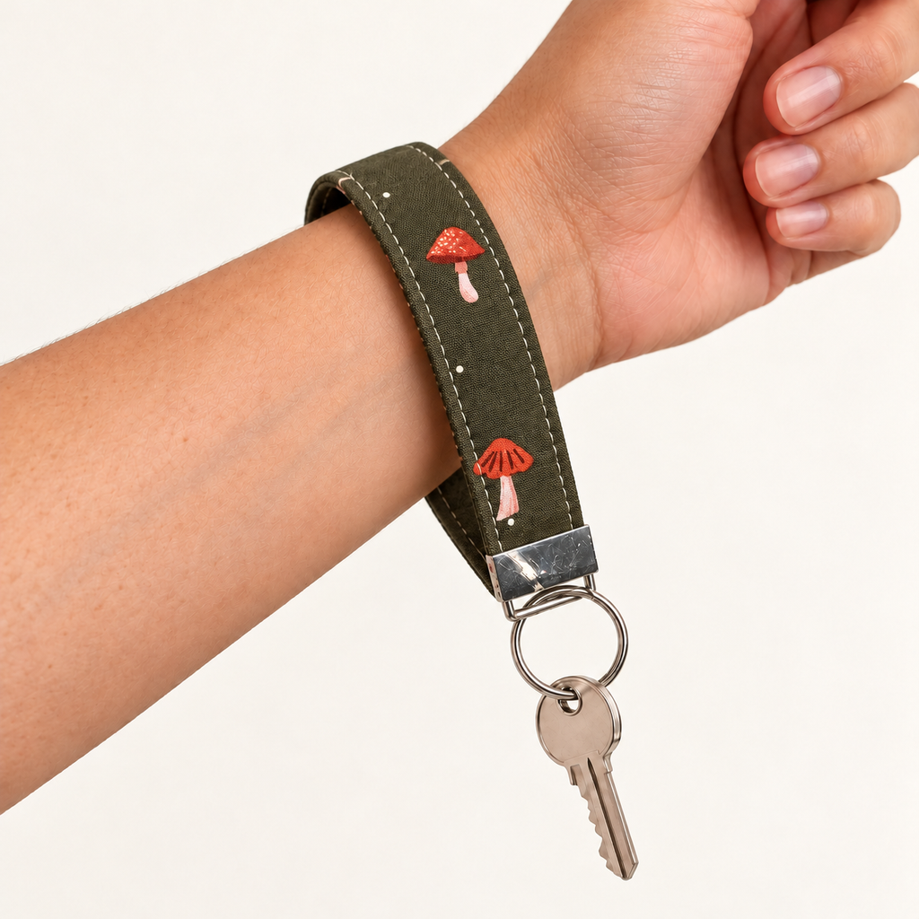 Shroom Service – Fabric Wristlet Keychain worn around a wrist with a key attached