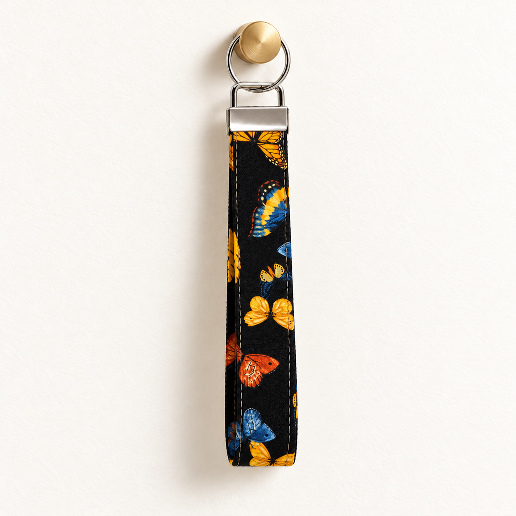 Social Butterfly – Fabric Wristlet Keychain hanging from a gold wall knob