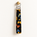 Social Butterfly – Fabric Wristlet Keychain hanging from a gold wall knob