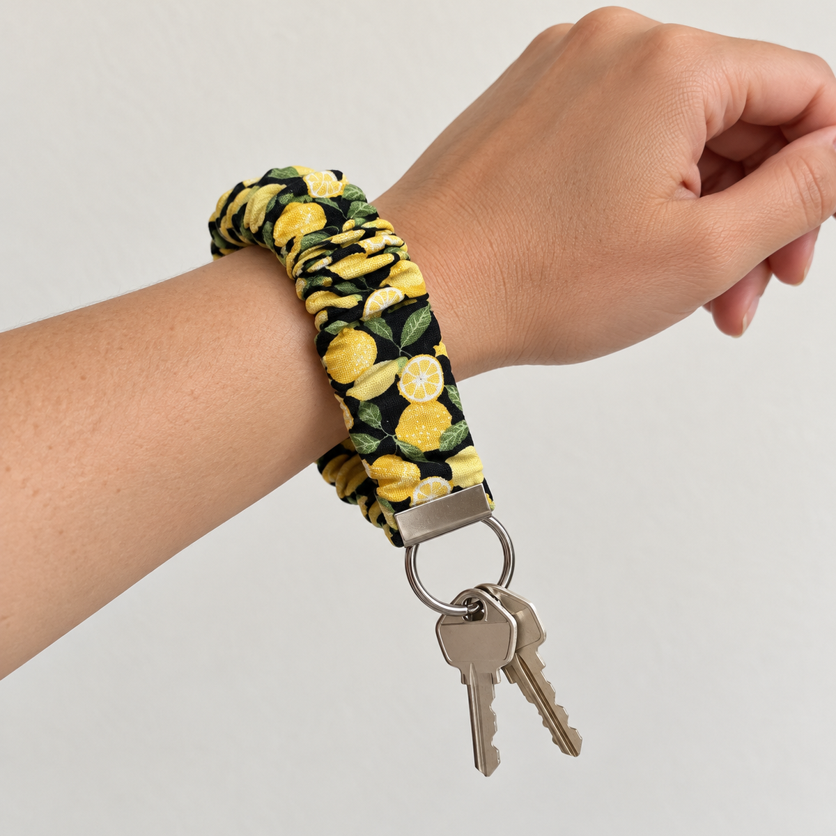 Squeeze the Day lemons scrunchie wristlet worn on wrist with keys