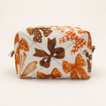 Head-on view of Take a Bow quilted cotton Mini Moment boxy bag with orange and brown bows