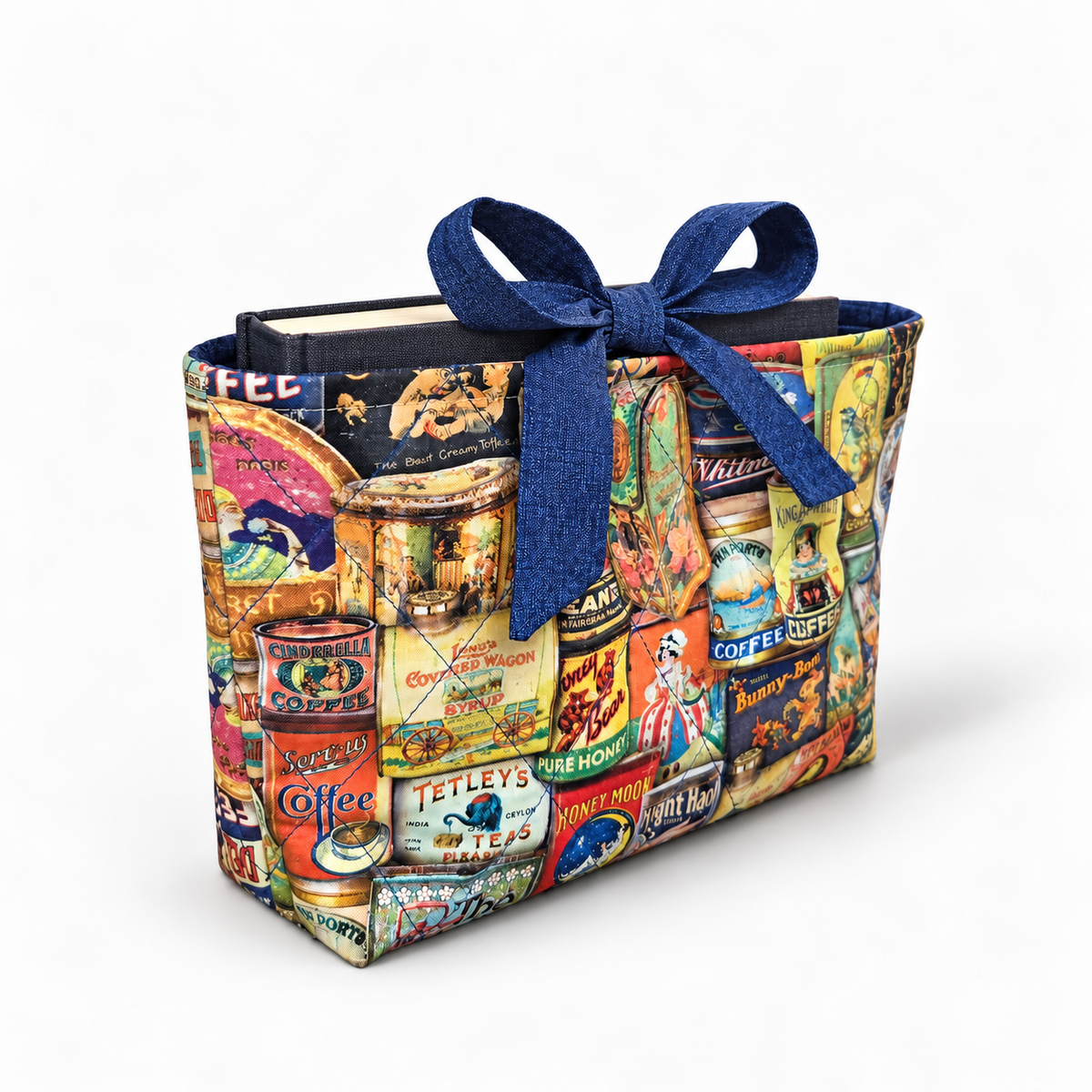 Tin the Mood book sleeve with rounded deep blue bow, three-quarter view with hardcover book inside