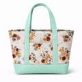 Floral tote bag with mint green handles and trim on a white background