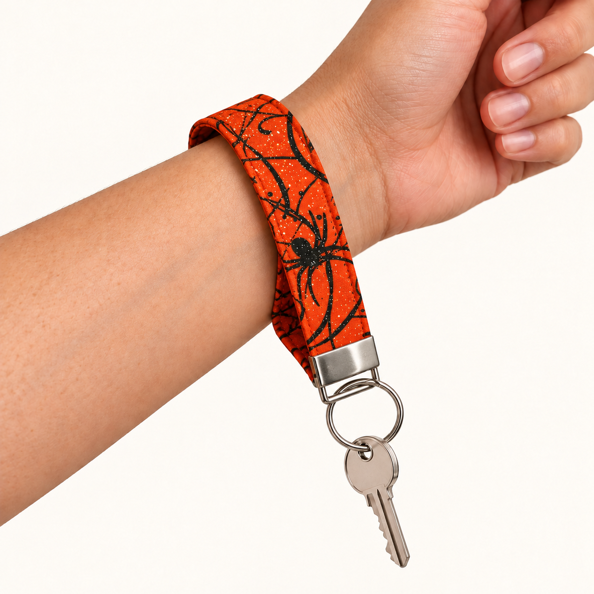 Web Hot – Fabric Wristlet Keychain worn around a wrist with a key attached