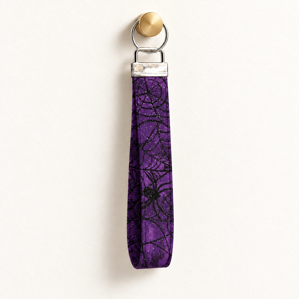 Web of Sass – Fabric Wristlet Keychain hanging from a gold wall knob