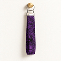 Web of Sass – Fabric Wristlet Keychain hanging from a gold wall knob