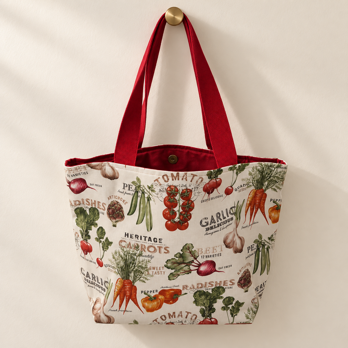 vintage vegetables and printed vegetable names on cream, red handles, red lining weekender tote hanging on a gold knob