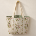 vertical rose garlands on pale cream, ivory handles, sage-green lining with white polka dots weekender tote hanging on a gold knob