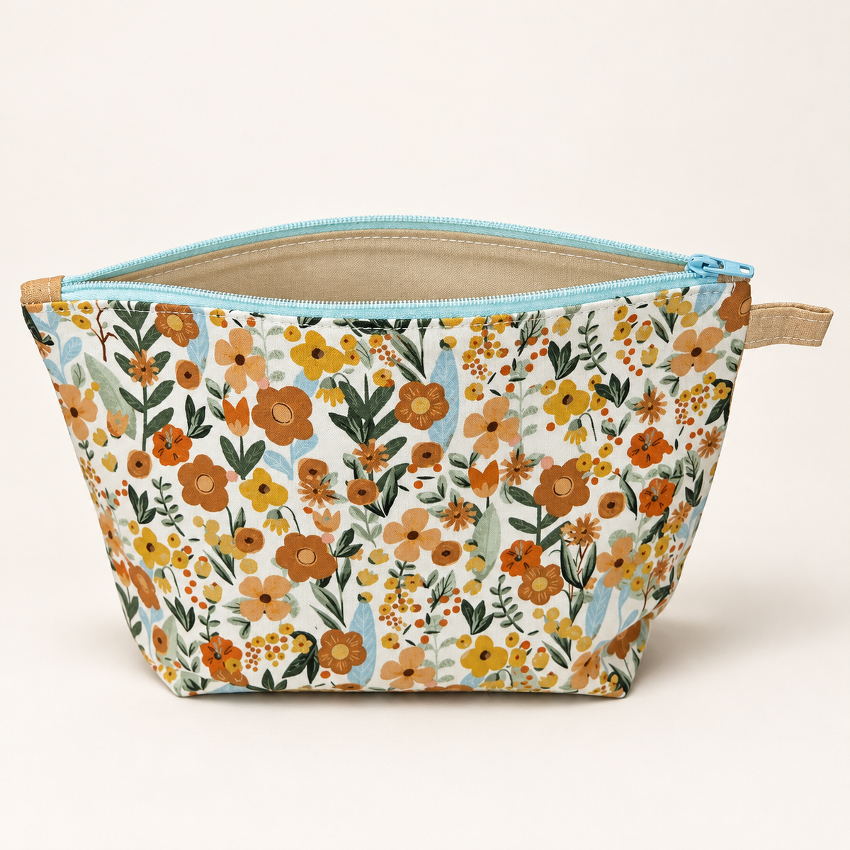 Wildflower Energy floral cotton pouch standing with beige lining and pale aqua zipper.