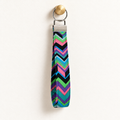 Zig Happens – Fabric Wristlet Keychain hanging from a gold wall knob