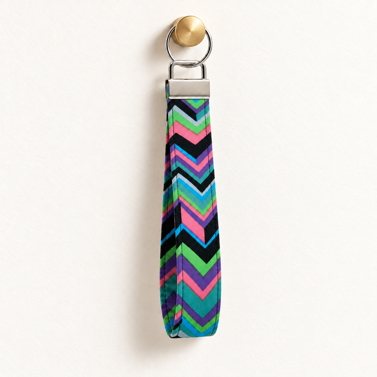 Zig Happens – Fabric Wristlet Keychain hanging from a gold wall knob